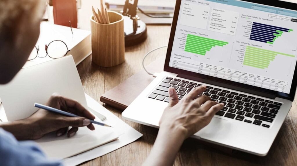 A beginner learning entrepreneurship online with graphs and notes on a laptop screen.