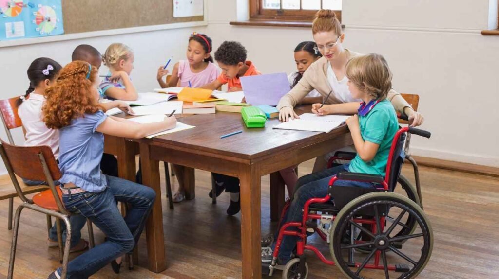 Teacher supporting students with and without disabilities in an inclusive classroom setting.