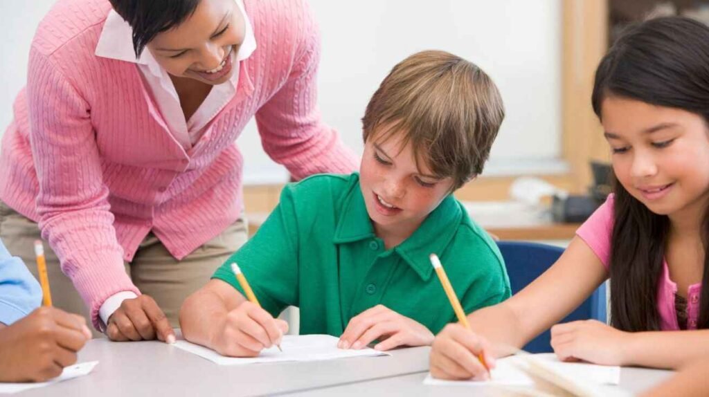 Student practicing writing while teacher provides feedback, showing writing as a core skill in education.